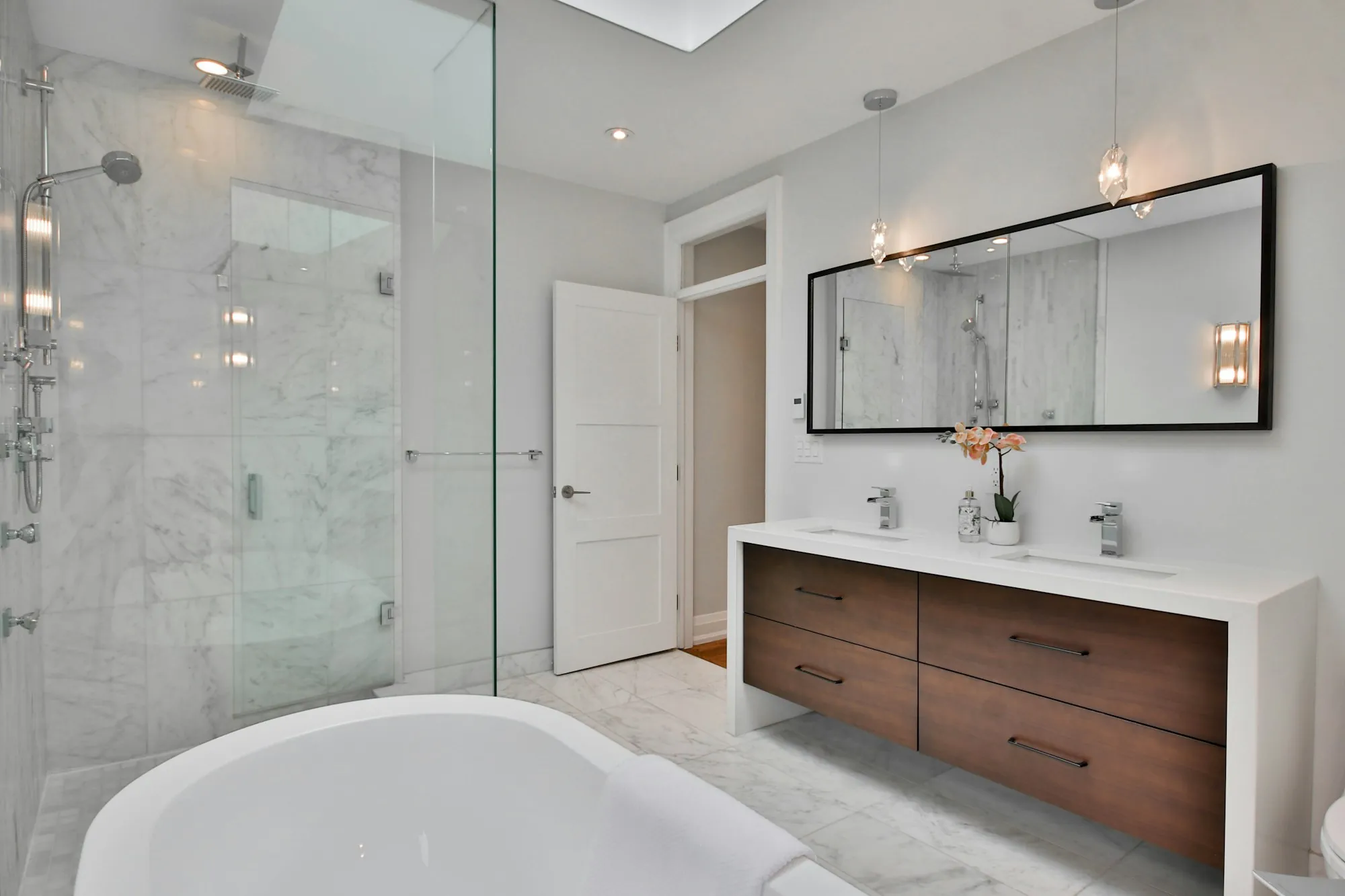 Remodeled bathroom with tiled walk-in shower and floating vanity
